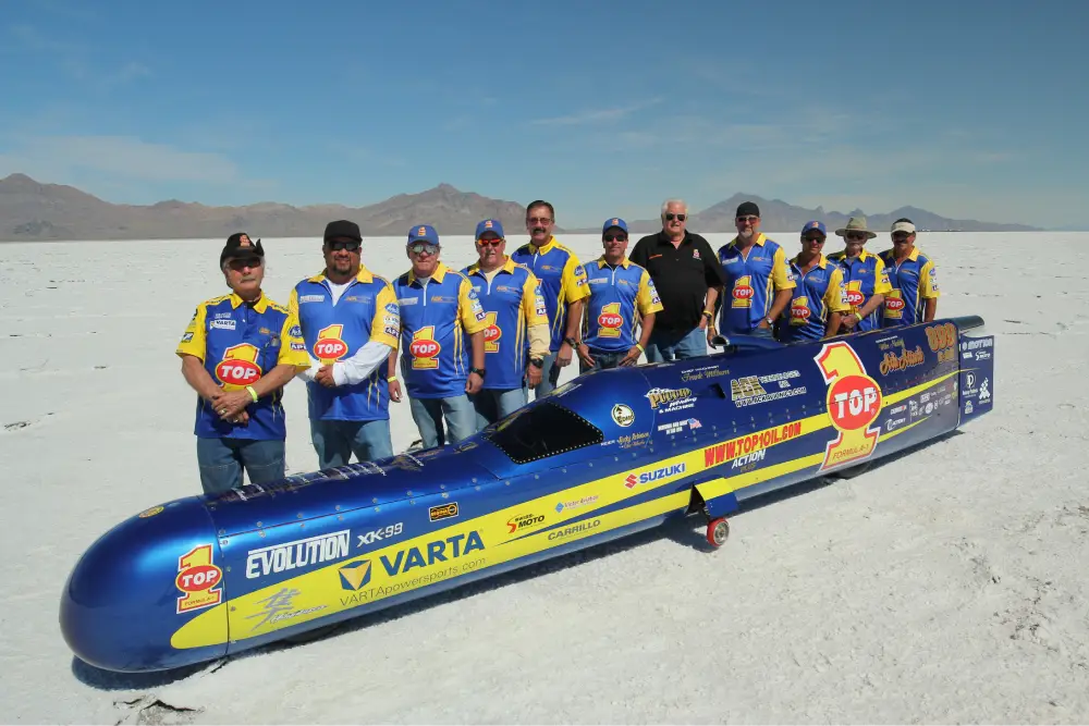 men standing behind the fastest motorcycle powered by top 1