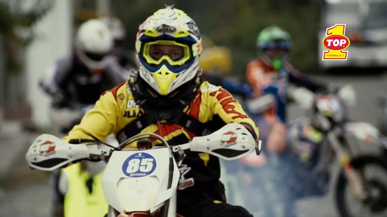a man wearing a helmet riding a motorcycle in a race