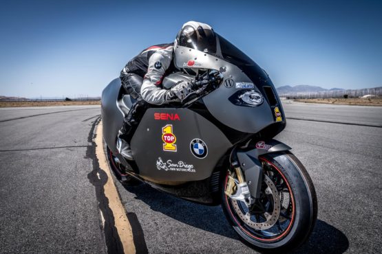Erin Sills speeds past on her BMW race bike. This machine runs on high-performance motorcycle oil.